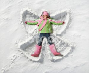 Adolescente haciendo angelitos en la nieve